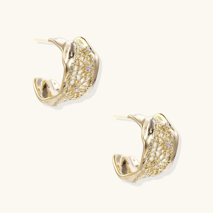 Gold-plated sculptural hoop earrings with geometric lattice centerband and sparkling zirconia on white background.