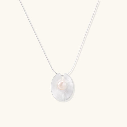 Sterling silver disc necklace with textured finish and centered freshwater pearl on delicate chain