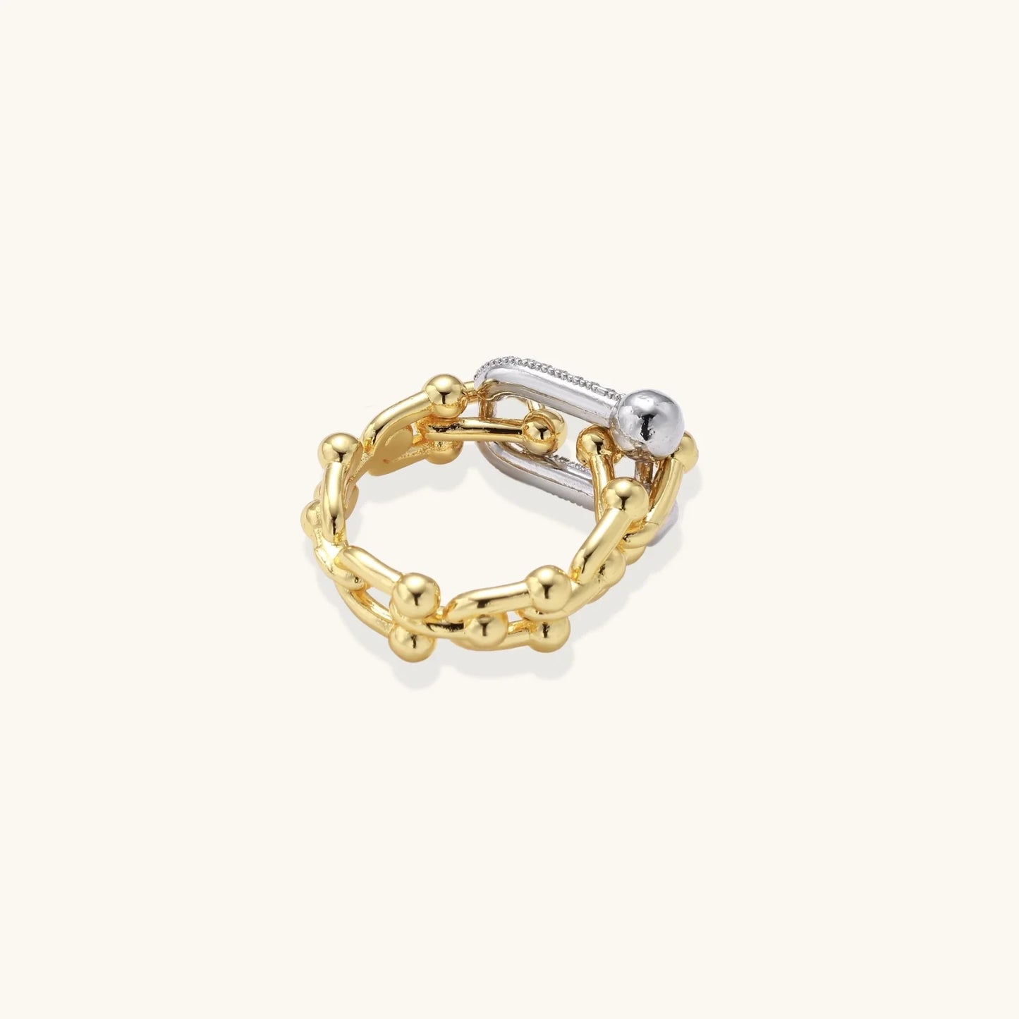 Triple-band gold ring with spherical bead chains and two crystal-pavé bars on cream background